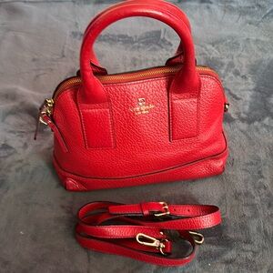 Red Kate Spade satchel with crossbody/shoulder strap